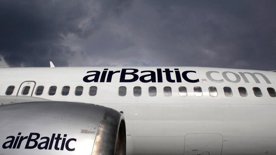 Nahaufnahme eines Flugzeugrumpfs mit Teil eines Triebwerks, die die Aufschrift "Air Baltic" tragen