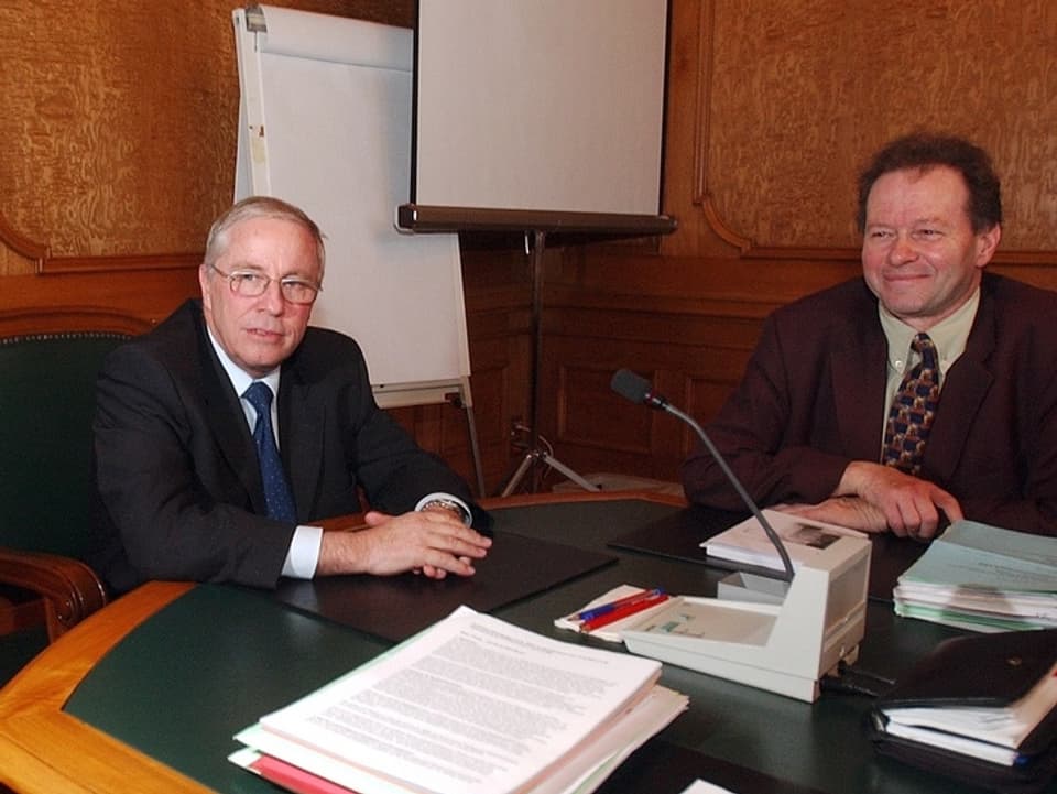 Christoph Blocher und Heiner Studer in einem Sitzungszimmer.