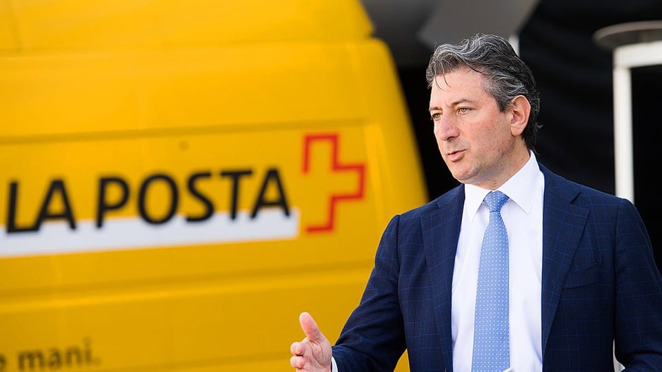 Post-Konzernchef Roberto Cirillo vor einem Auslieferwagen der Schweizer Post.