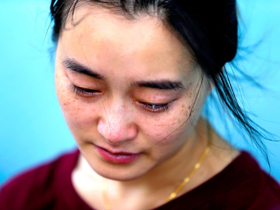 Nahaufnahme der Mutter eines Passagiers der Unglücksmaschine MH370 der Malaysia Airline. Sie weint.