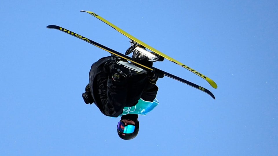 Ein Skifahrer springt in die Höhe.