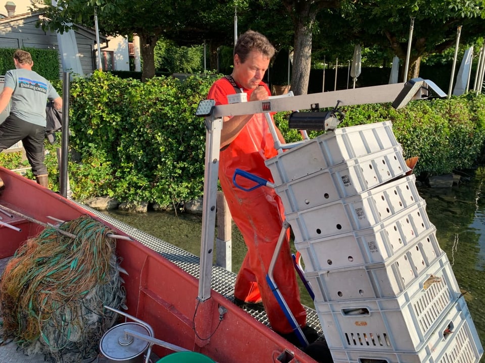 Fischer entlädt Kisten mit Fang vom Boot