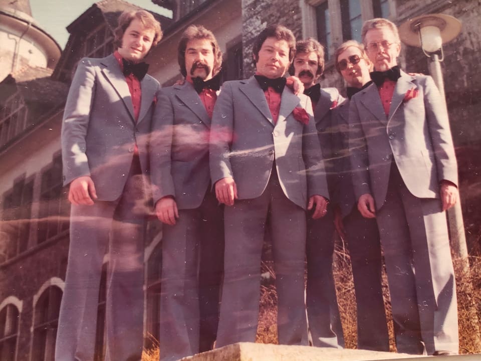 Sechs Männer tragen denselben Anzug.