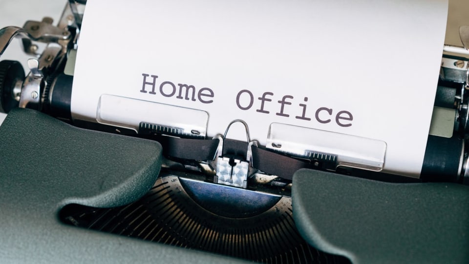 Eine Schreibmaschine ist abgebildet. In der Maschine ist ein Blatt mit dem der Überschrift Home Office