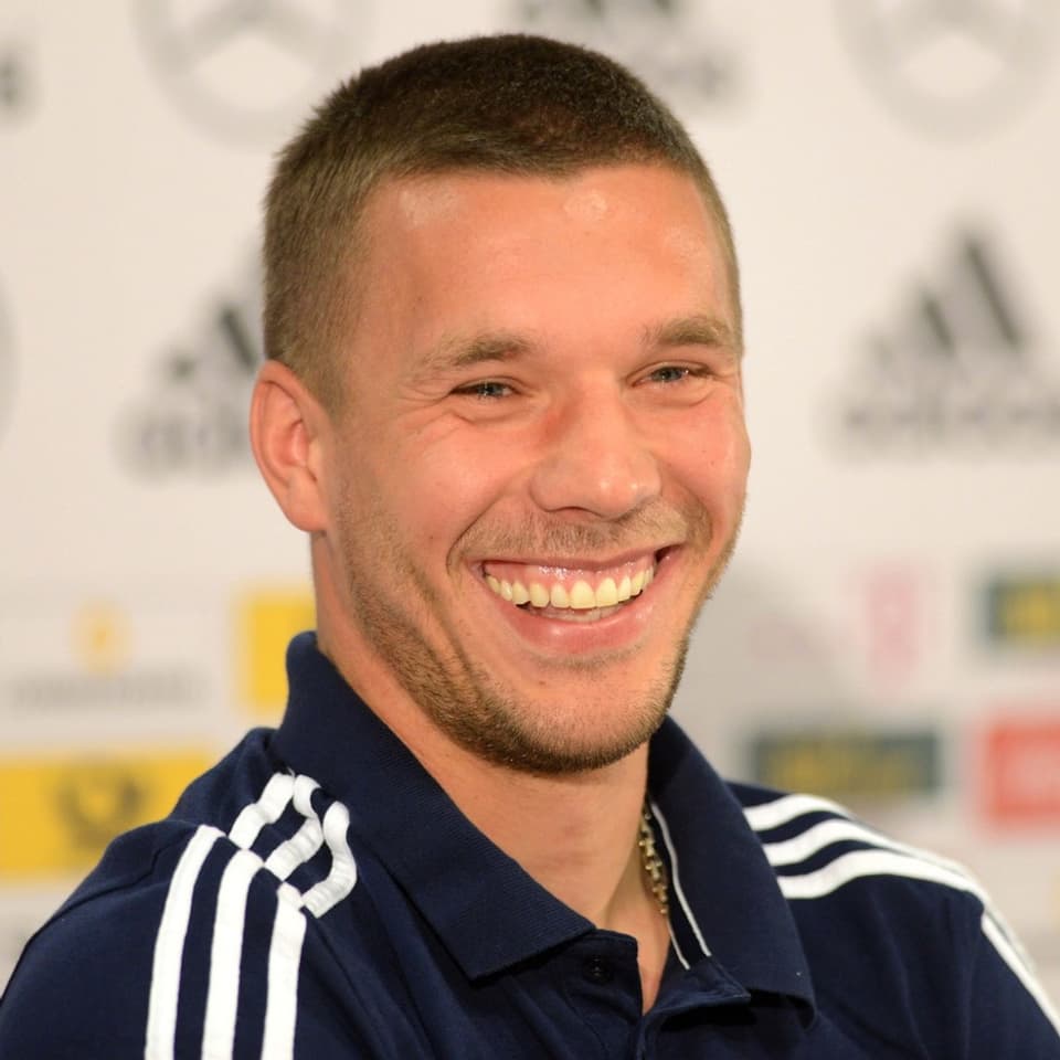 Lukas Podolski lacht in die Kamera.