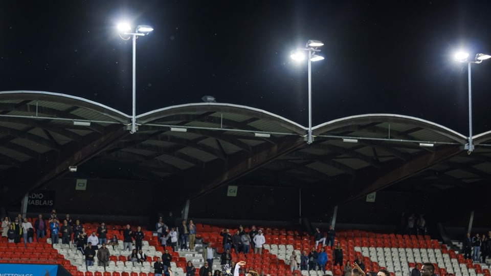 Dach eines Fussball-Stadions mit eingeschaltetem Flutlicht.