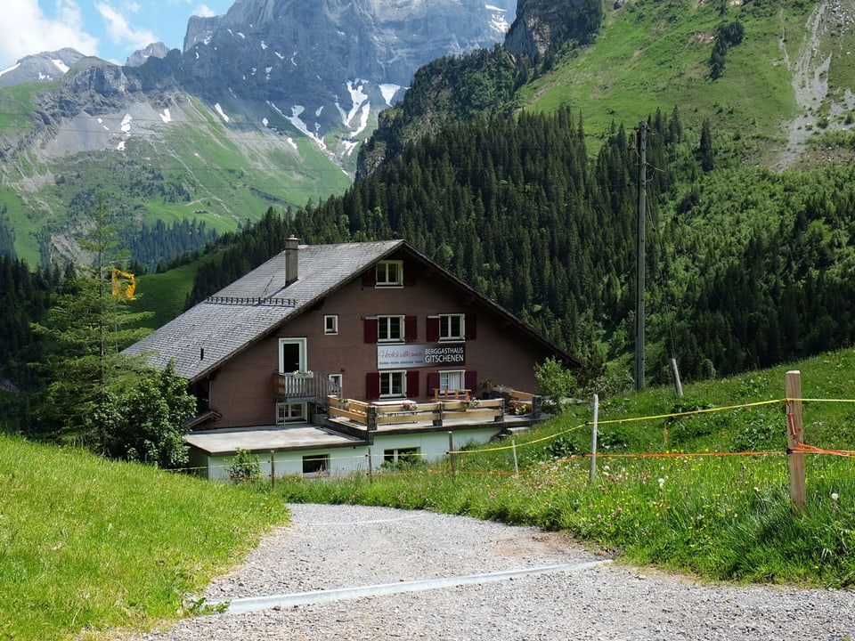 Blick auf ein braunes Berggasthaus.