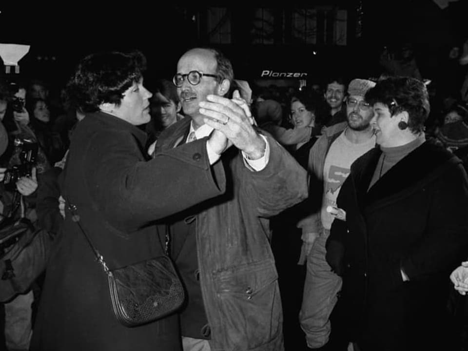 Schwarzweiss Foto: Ein Mann und eine Frau tanzen in der Menge.