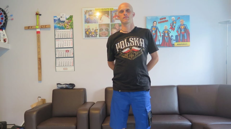 Mann mit Shorts und Glatze im Wohnzimmer