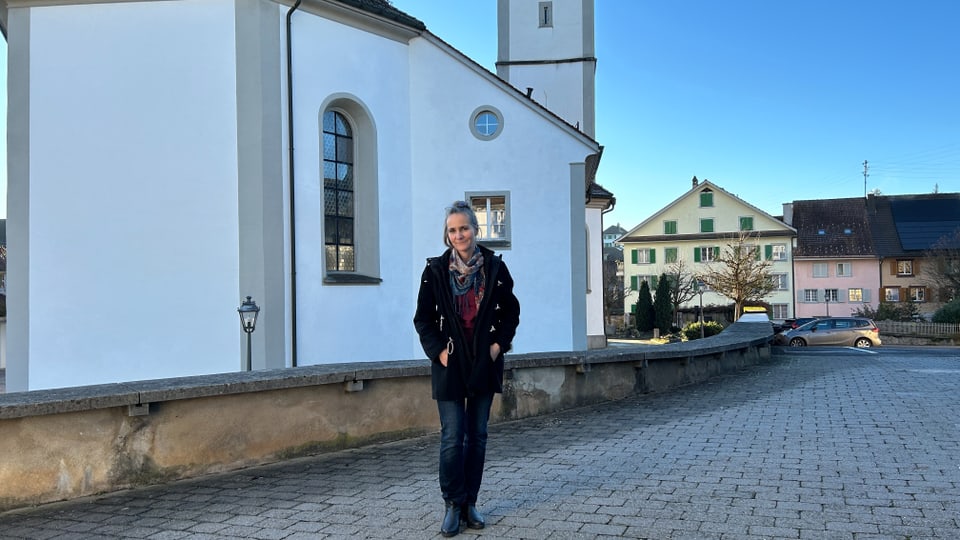 Frau steht vor einer Kirche