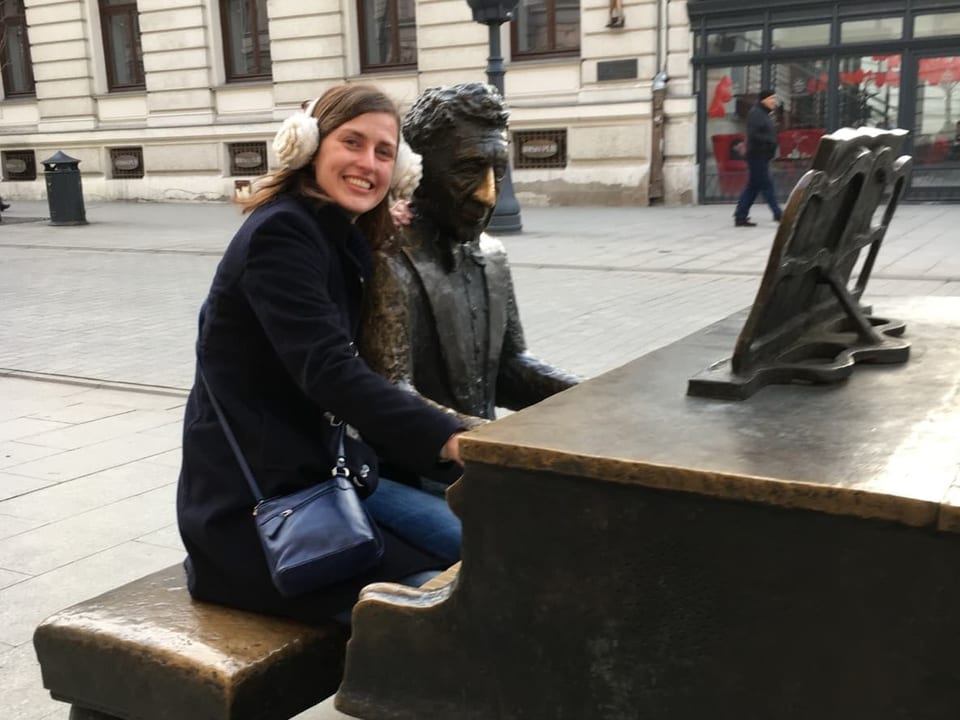 Osteuropa-Korrespondentin Sarah Nowotny sitzt in Warschau an einer Klavier-Statute.