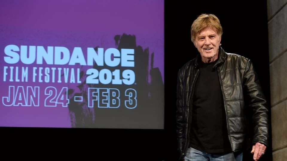 Robert Redford steht vor der Leinwand des «Sundance Film Festival».