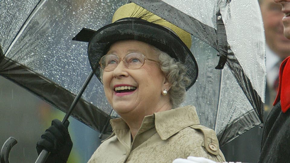 Queen Elizabeth mit Regenschirm, am lächeln. 