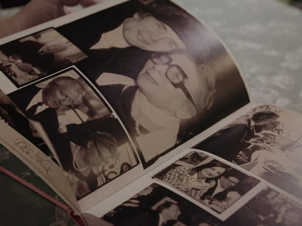Fotoalbum auf einem Tisch mit schwarz-weiss Bildern von Personen.