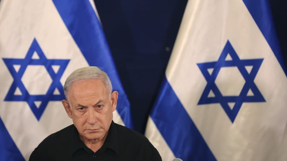 Netanjahu vor israelischen Flaggen.