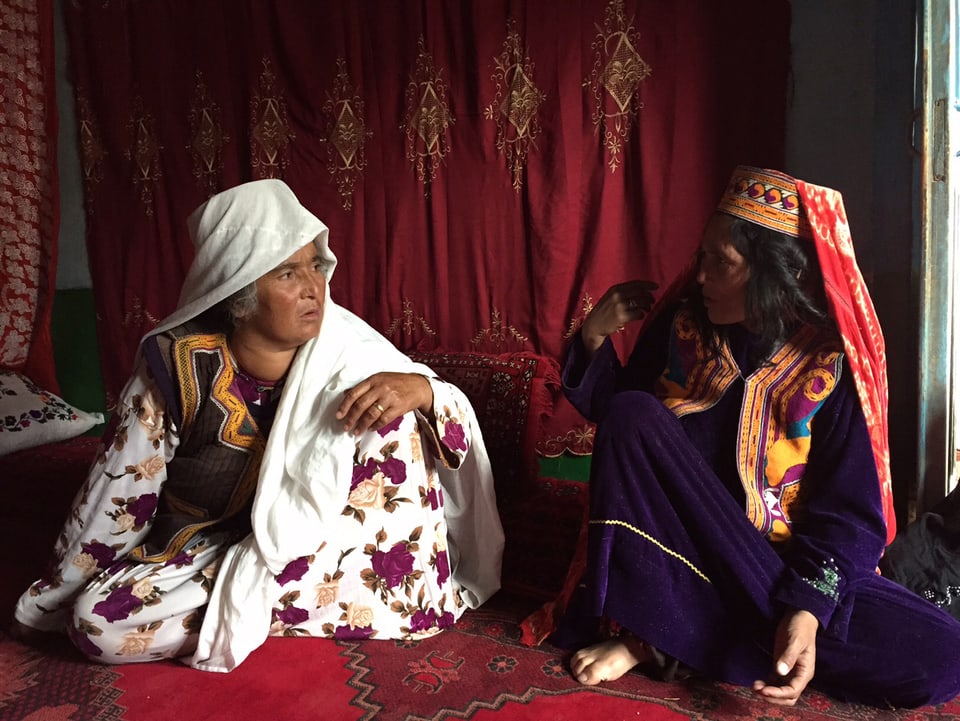 Drei Frauen mit Kopftüchern. Rechts Teppichknüpferin Haji Apa Gul.