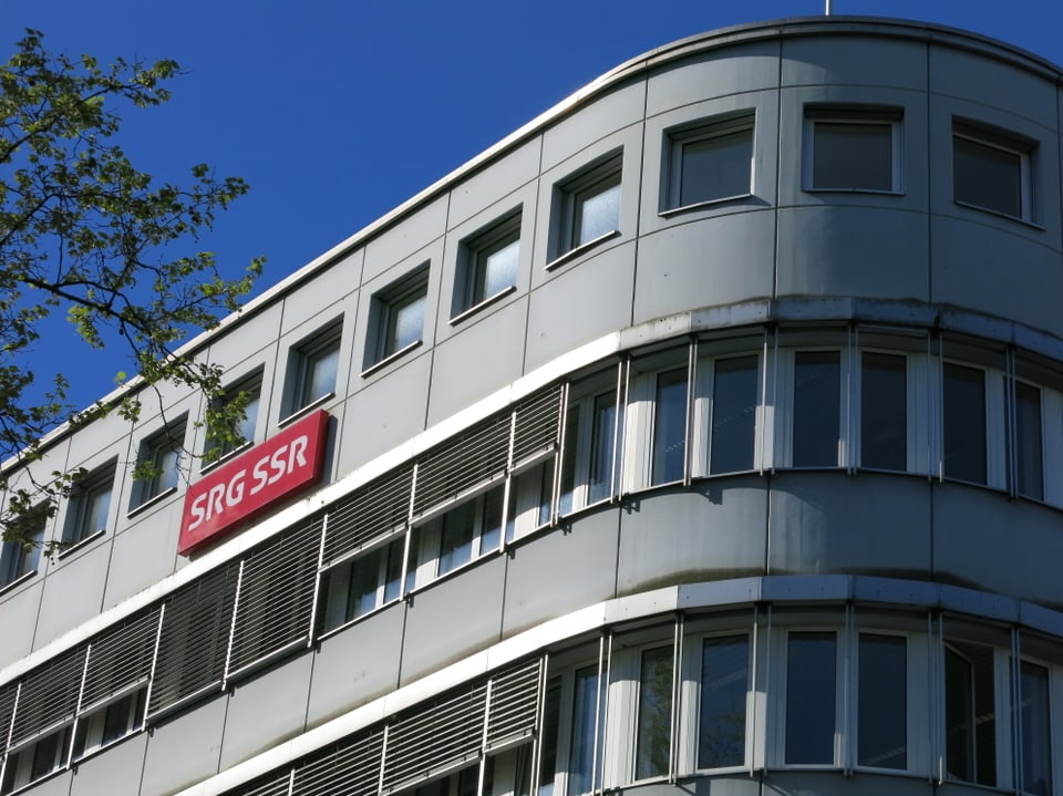Ein helles Gebäude vor blauem Himmel mit der Aufschrift SRG SSR.