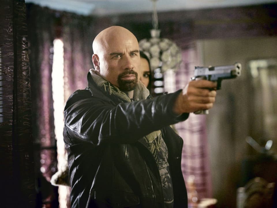 John Travolta zielt mit einer Pistole.