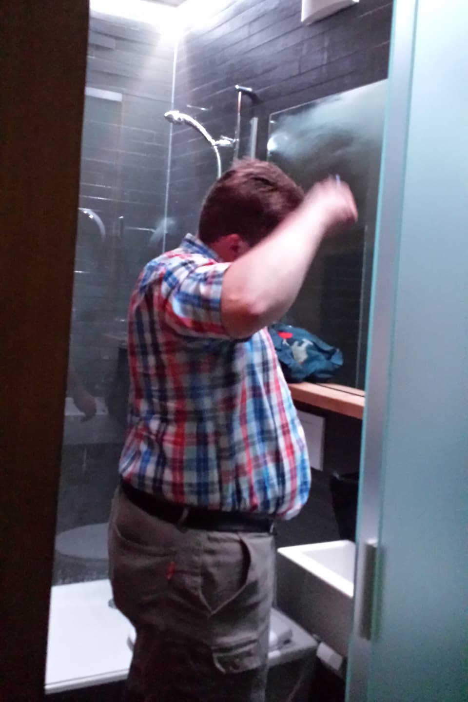 Der Hotelgast kämmt sich im Badezimmer vor dem Spiegel die Haare.