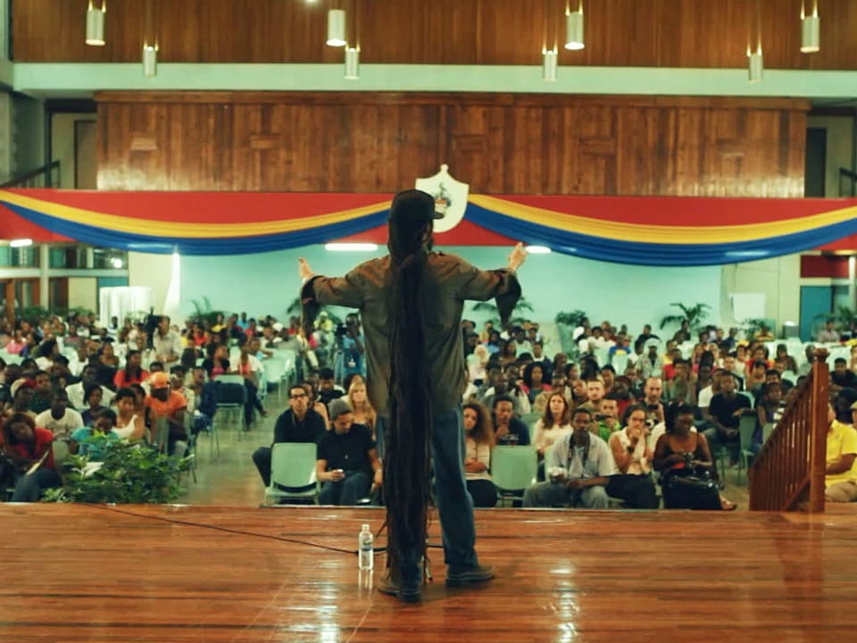 Man sieht Damian Marley vor einer Schulklasse.