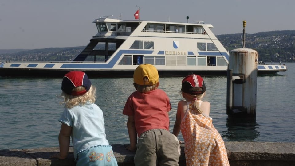 Drei Kinder bestaunen eine Fähre auf dem Zürichsee