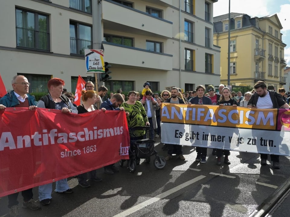 Gruppe von Menschen auf einer Demonstration mit einem grossen Banner, auf dem 'Antifaschismus since 1863' steht.