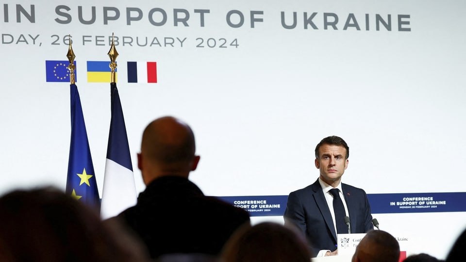 Mann steht vor Publikum, im Hintergrund steht «In Support of Ukraine»