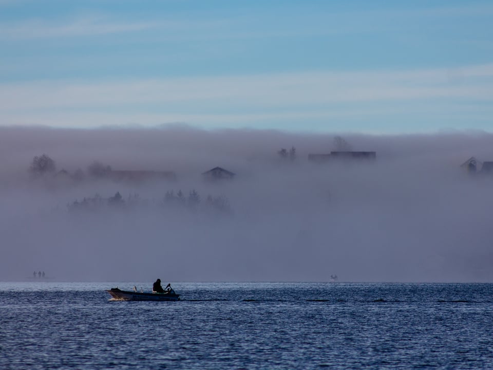 Im Vordergrund ein Fischer, im Hintergrund eine Nebelwand.