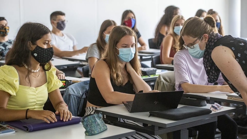 Klassenzimmer mit Schülerinnen und Schülern, die Maske tragen.