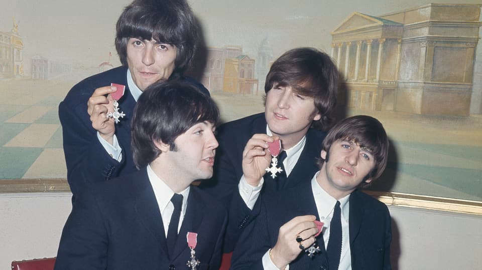 Die Beatles in schwarzen Anzügen.