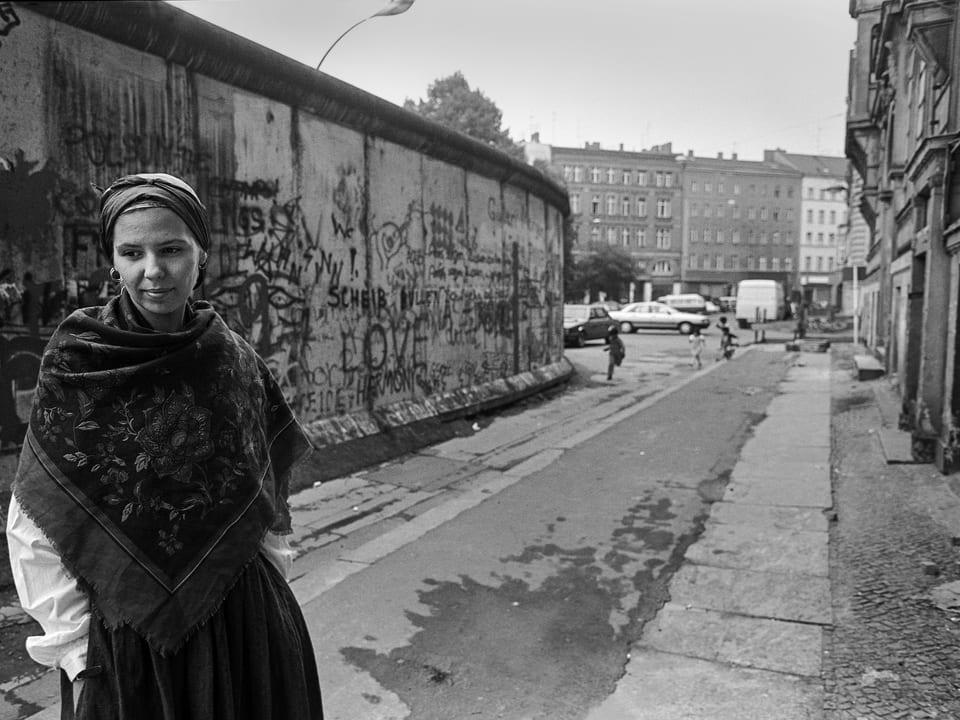 Frau mit Kopftuch vor der Mauer in Kreuzberg 1988