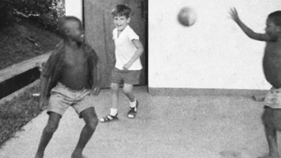 Kindheit in Afrika Zwei dunkelhäutige Kinder spielen mit einem weissen Kind Ball