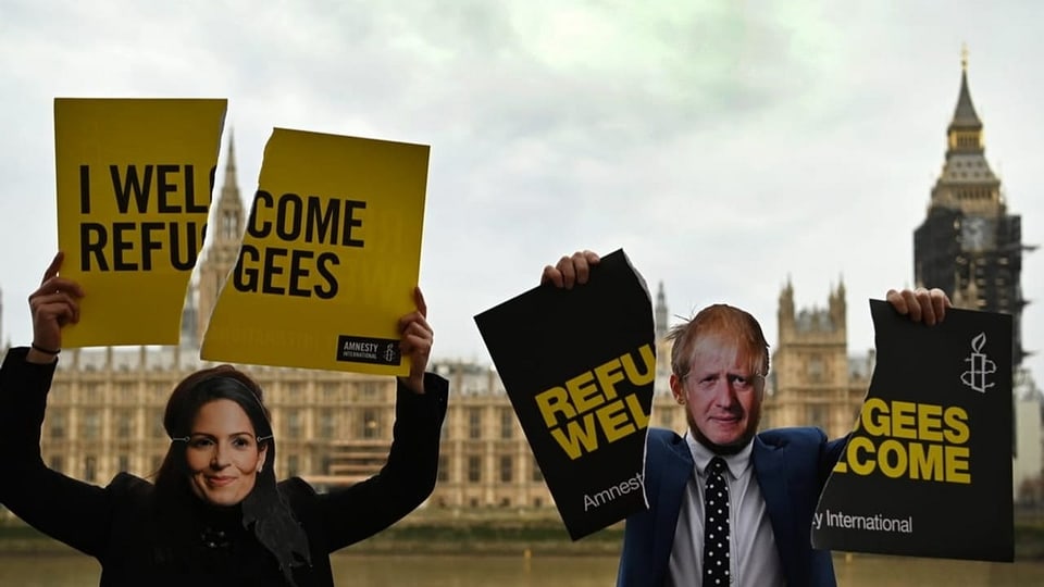 Aktivisten verkleidet als Priti Patel (links)  Boris Johnson (rechts) 
