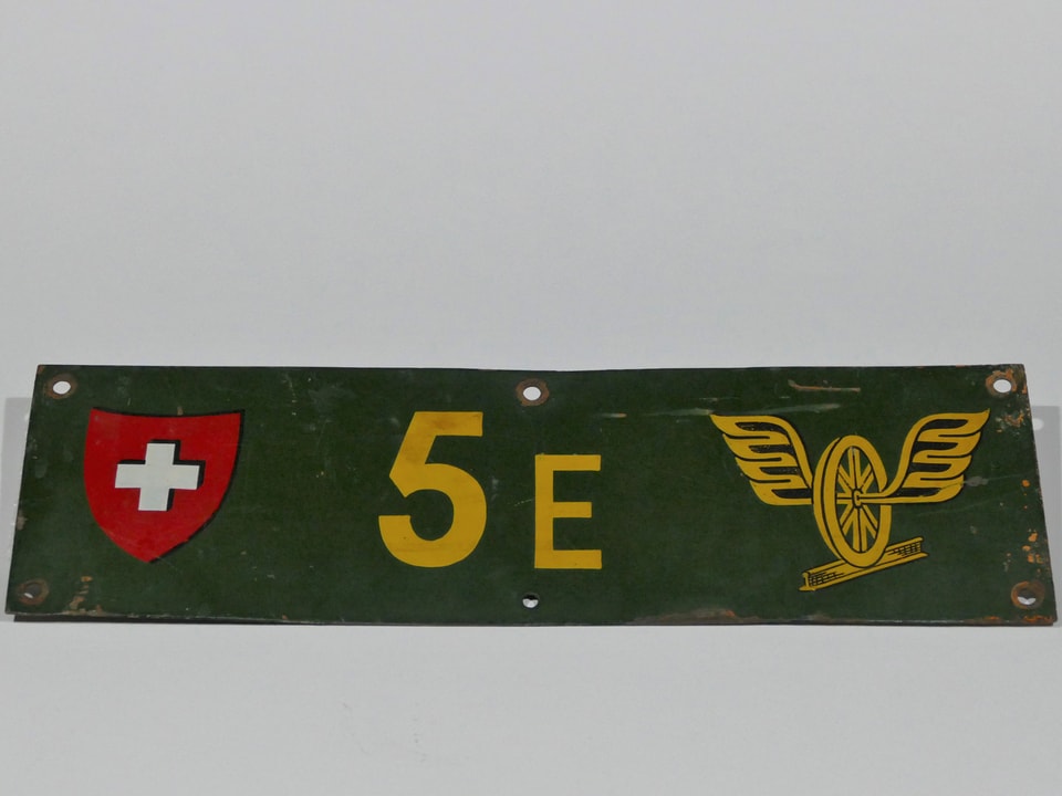 Ein grünes Schild mit Schweizerkreuz, «5», «E» und einem Rad mit Flügel.