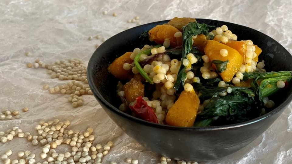Dishes with pearl couscous, pumpkin and spinach.