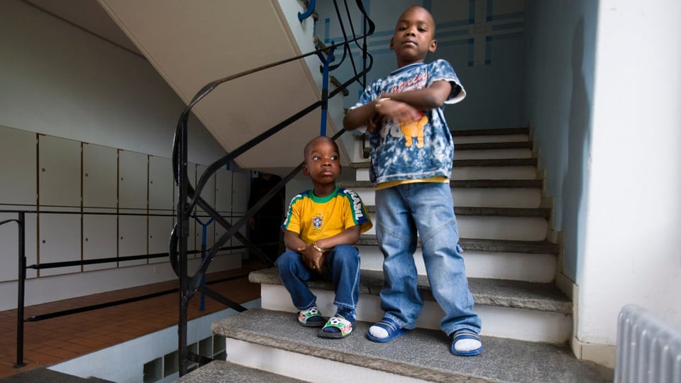Zwei Kinder im Asylheim stehen auf Treppe