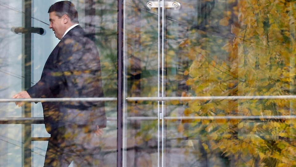 Parteichef Sigmar Gabriel hinter einer Glasfassade.