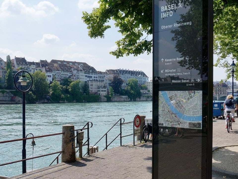 Blick auf eine Stele. Man blickt vom Kleinbasler Rheinufer aufs Grossbasel. 
