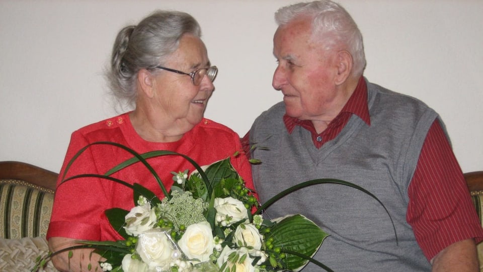 Hanni und Fritz Maurer lächeln sich an, sie hält einen Blumenstrauss in der Hand.