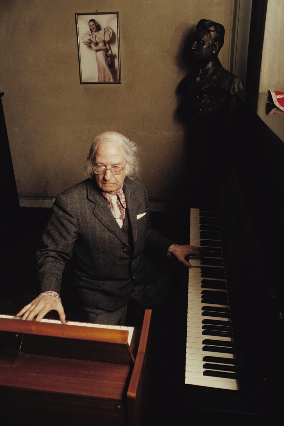 Ein Mann im Altersheim zwischen zwei Klavieren.