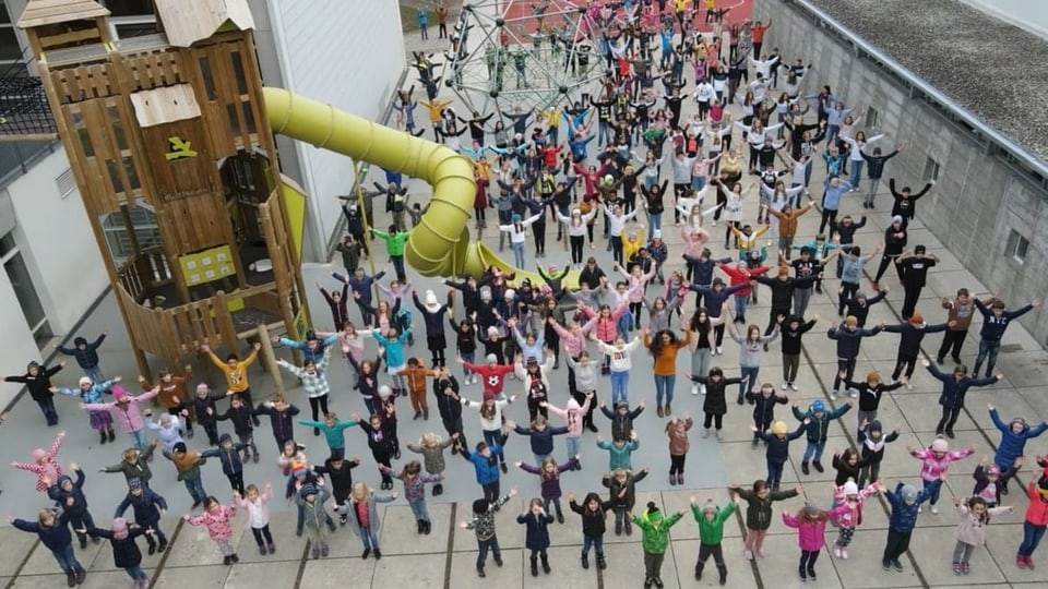 Auf dem Pausenplatz in Glis wurde 2021 getanzt Hunderte Kinder tanzen auf einem Pausenplatz bei der Aktion Say Hi