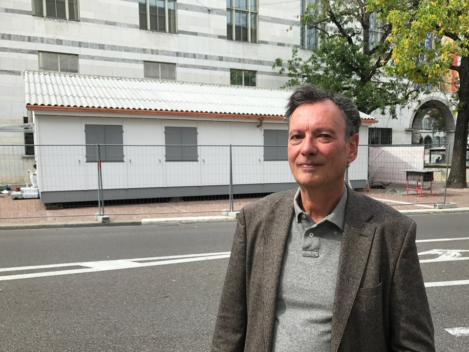 Pascal Trudon steht vor seiner Kunstinstallation (ein Häuschen), dahinter das Kunstmuseum