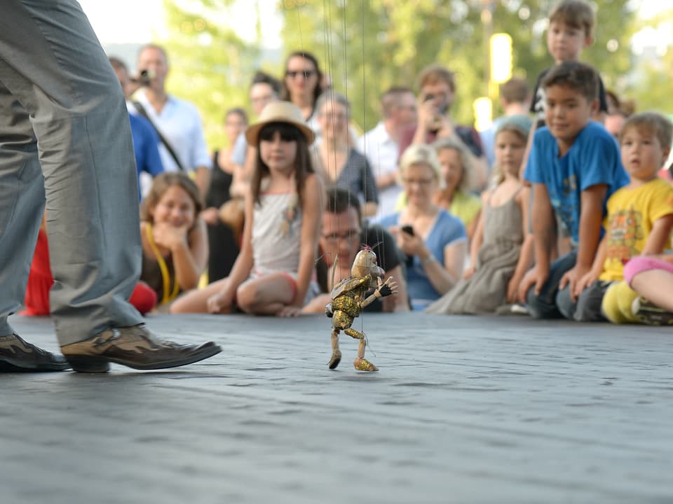 Eine kleine Marionetten-Biene auf der Bühne, Kinder schauen zu.