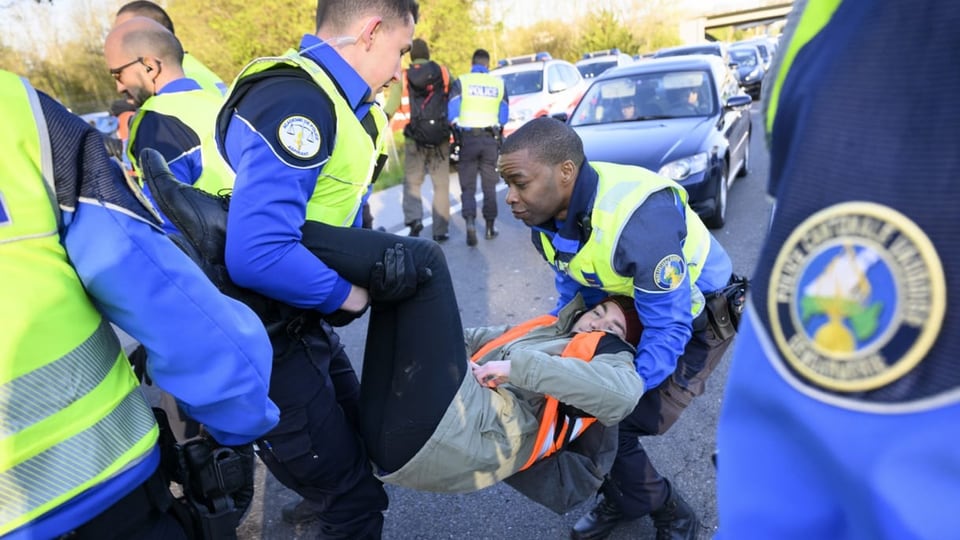 Polizisten führen in Lausanne einen Klimaaktivisten ab.