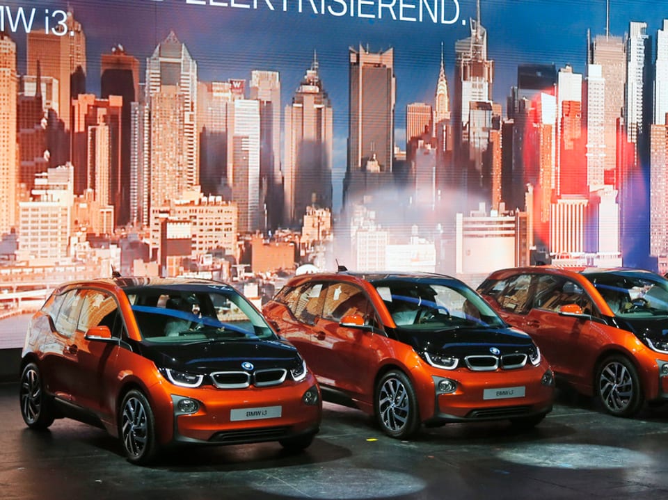 Orange-farbene Elektro-Autos von BMW als Ausstellungsmodell