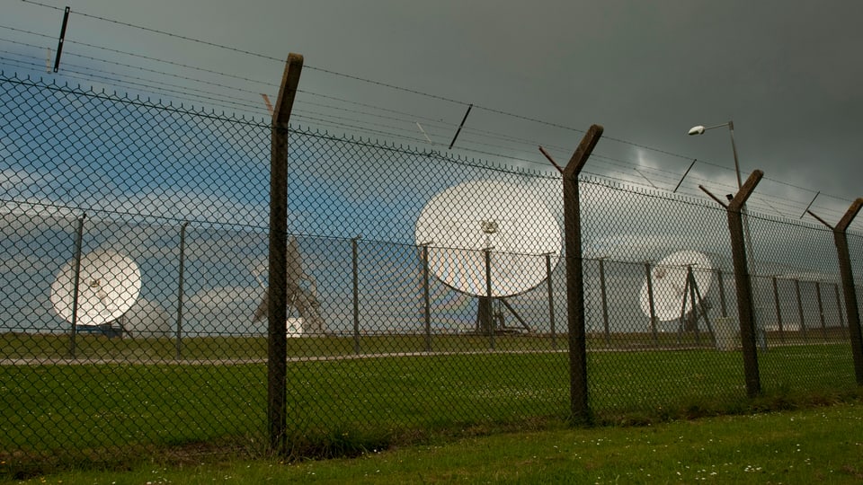 Satellitenschüsseln hinter einem Zaun