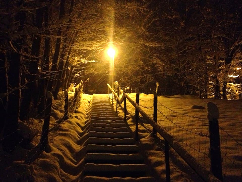 Verschneiter Treppenaufstieg in der Nacht.