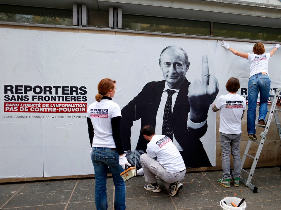 Plakat der Organisatin Reporter ohne Grenzen: Darauf ist Putin mit ausgestreckten Mittelfinger zu sehen.
