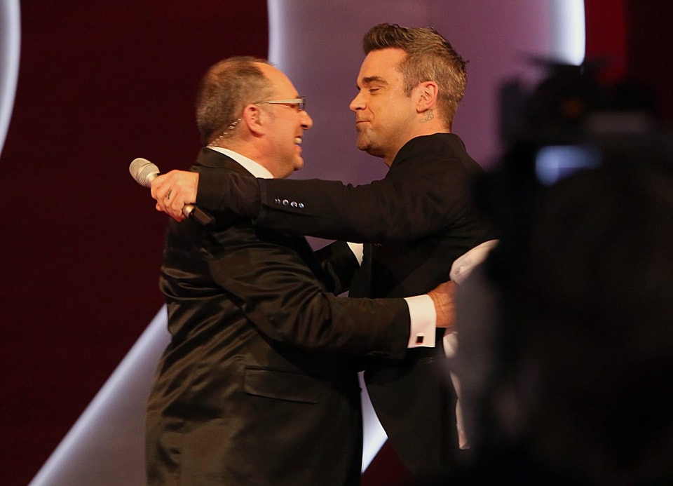 Beni Thurnheer umarmt Robbie Williams.