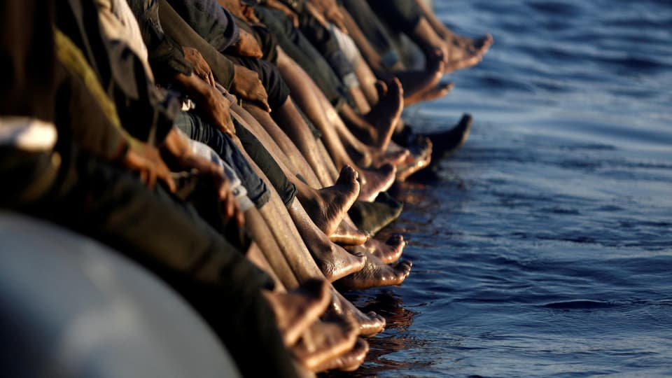 Füsse von Migranten auf einem Boot im Mittelmeer